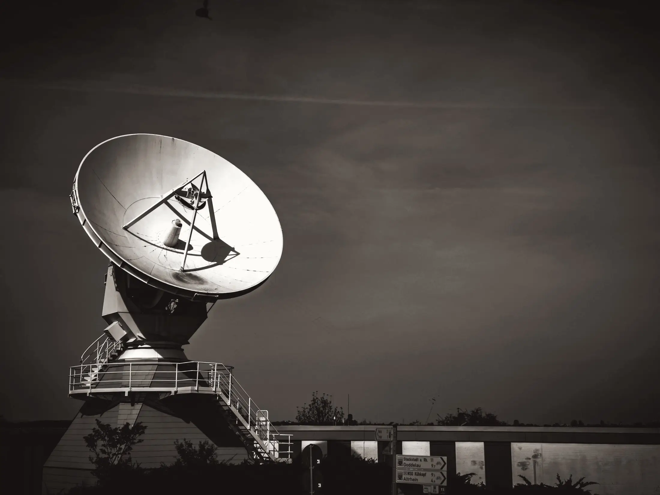 Platformun üzerinde duran büyük bir radyo teleskobu.